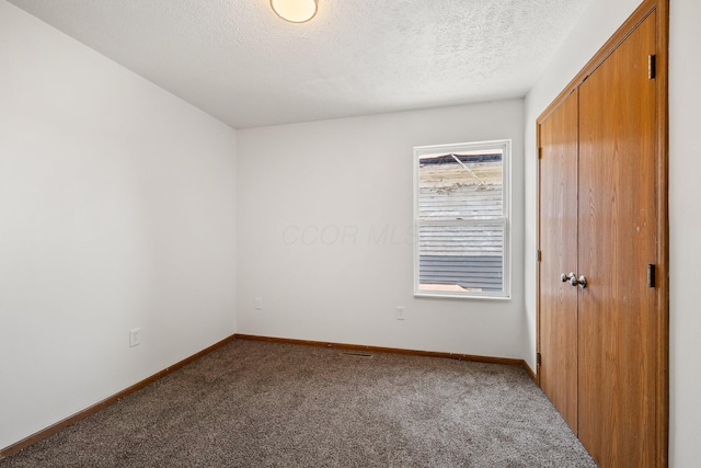 223 E 2nd St, Mansfield, OH 44902 - unfurnished bedroom featuring carpet flooring, a closet, and a textured ceiling