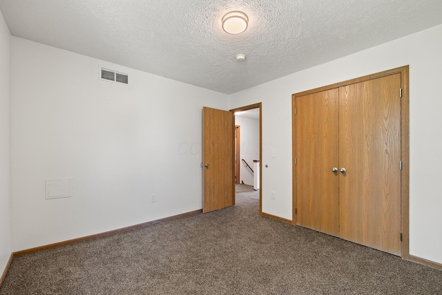 223 E 2nd St, Mansfield, OH 44902 - unfurnished bedroom with dark colored carpet, a closet, and a textured ceiling