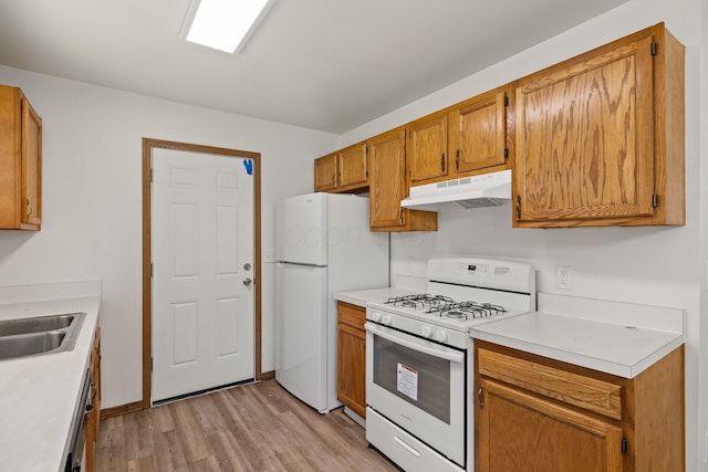 223 E 2nd St, Mansfield, OH 44902 - kitchen with white appliances, under cabinet range hood, light wood finished floors, light countertops, and brown cabinetry