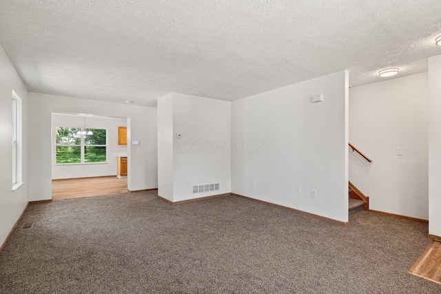 223 E 2nd St, Mansfield, OH 44902 - carpeted empty room featuring a textured ceiling and stairway