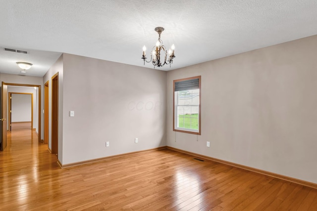 159 Hathaway Rd, West Jefferson, OH 43162 - unfurnished room with a chandelier, light wood finished floors, and a textured ceiling