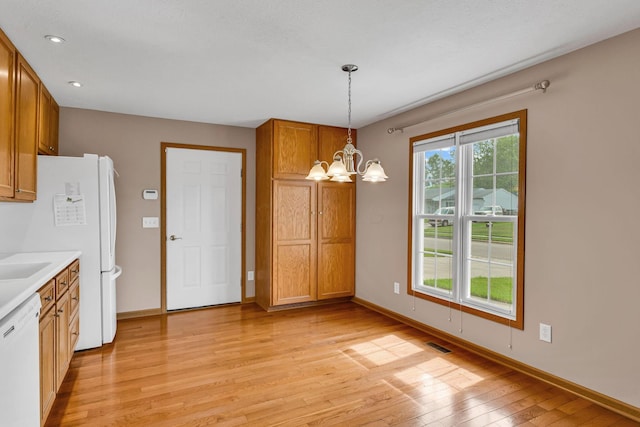 159 Hathaway Rd, West Jefferson, OH 43162 - kitchen featuring white dishwasher, a chandelier, light wood-type flooring, brown cabinetry, and light countertops