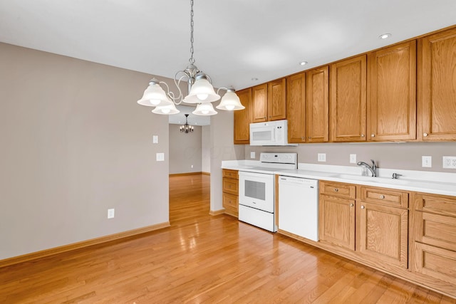 159 Hathaway Rd, West Jefferson, OH 43162 - kitchen with white appliances, a chandelier, light countertops, light wood-style flooring, and brown cabinetry