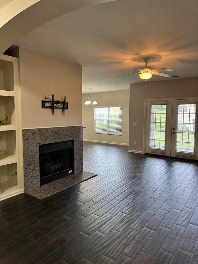 3757 Birkland Cir, Lewis Center, OH 43035 - unfurnished living room with dark wood-type flooring, a premium fireplace, a ceiling fan, built in features, and a chandelier