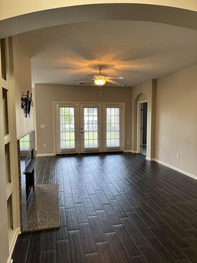 3757 Birkland Cir, Lewis Center, OH 43035 - unfurnished living room featuring a ceiling fan, dark wood-style flooring, a fireplace, and arched walkways