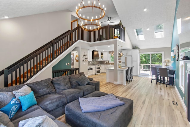 168 Thornapple Trl, Delaware, OH 43015 - living area featuring high vaulted ceiling, a chandelier, light wood-style flooring, a skylight, and a textured ceiling