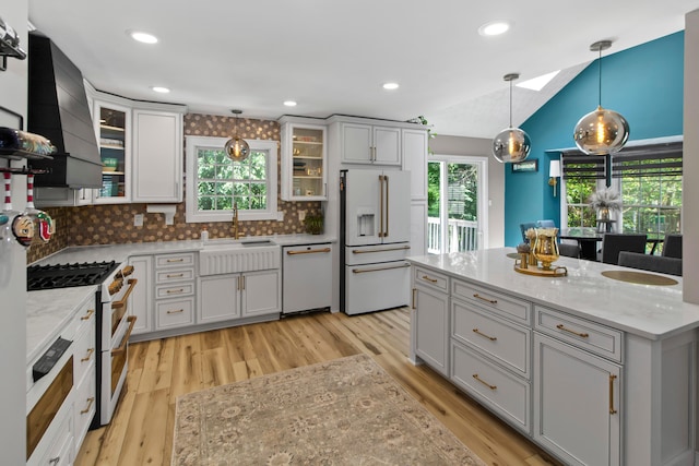 168 Thornapple Trl, Delaware, OH 43015 - kitchen featuring high quality appliances, wall chimney exhaust hood, light wood-style flooring, lofted ceiling, and decorative backsplash