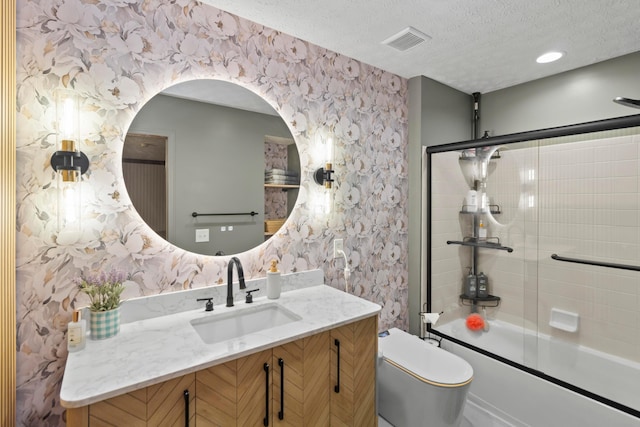 168 Thornapple Trl, Delaware, OH 43015 - full bath featuring wallpapered walls, vanity, shower / bath combination with glass door, and a textured ceiling