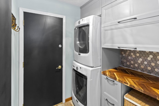 168 Thornapple Trl, Delaware, OH 43015 - laundry area featuring stacked washer / drying machine and cabinet space