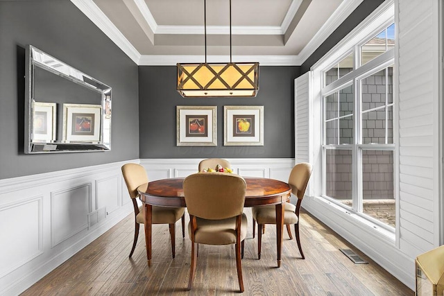 3017 Highland Woods Blvd, New Albany, OH 43054 - dining area featuring hardwood / wood-style floors, a raised ceiling, ornamental molding, a wainscoted wall, and a decorative wall
