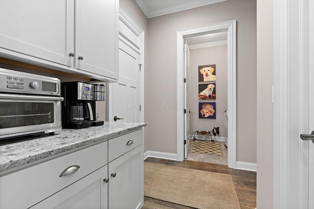 3017 Highland Woods Blvd, New Albany, OH 43054 - kitchen with dark wood finished floors, ornamental molding, white cabinetry, and light stone countertops