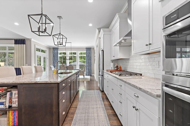 3017 Highland Woods Blvd, New Albany, OH 43054 - kitchen with stainless steel appliances, white cabinets, a chandelier, a center island with sink, and dark brown cabinets
