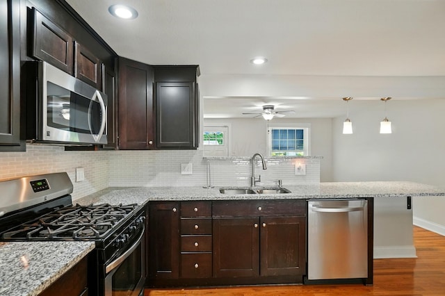 1574 River Bend Rd, Columbus, OH 43223 - kitchen with stainless steel appliances, a peninsula, decorative backsplash, ceiling fan, and light stone countertops