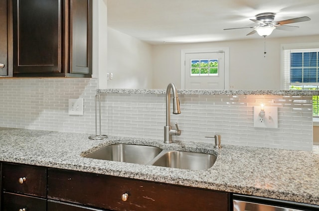 1574 River Bend Rd, Columbus, OH 43223 - kitchen featuring dark brown cabinetry, backsplash, a ceiling fan, and light stone counters