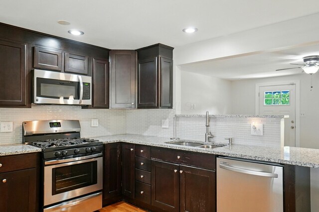 1574 River Bend Rd, Columbus, OH 43223 - kitchen featuring appliances with stainless steel finishes, a peninsula, backsplash, and dark brown cabinetry
