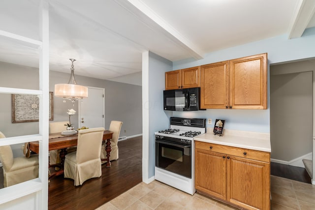 1276 Bryson Rd, Columbus, OH 43224 - kitchen featuring white gas range, black microwave, light countertops, beamed ceiling, and brown cabinetry