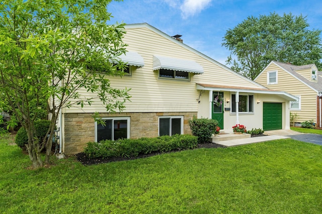 1276 Bryson Rd, Columbus, OH 43224 - view of front facade with asphalt driveway, a front yard, and an attached garage