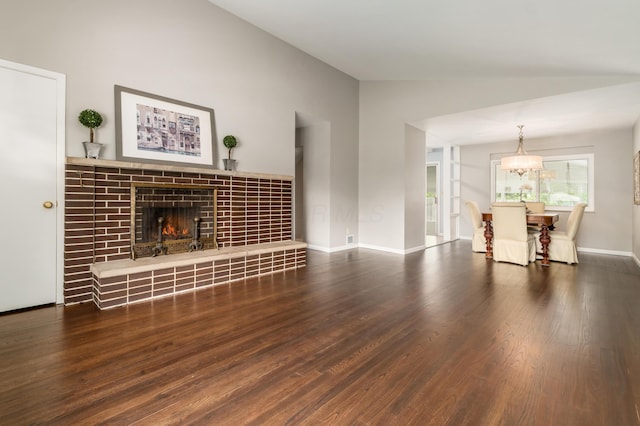1276 Bryson Rd, Columbus, OH 43224 - unfurnished living room featuring lofted ceiling, wood finished floors, a tile fireplace, and a chandelier