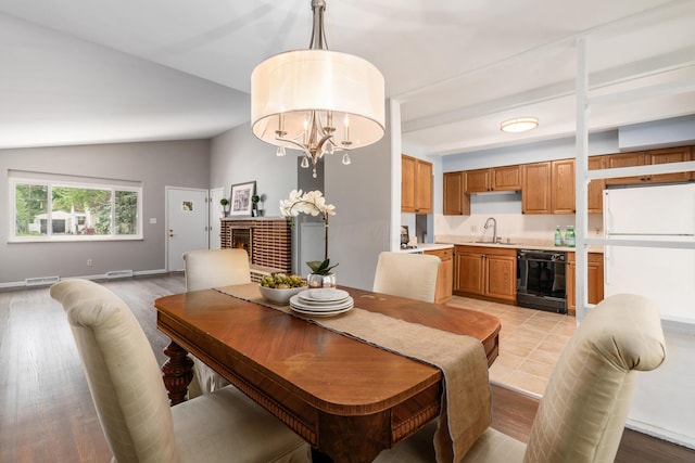 1276 Bryson Rd, Columbus, OH 43224 - dining space featuring lofted ceiling, a chandelier, light wood finished floors, and a fireplace