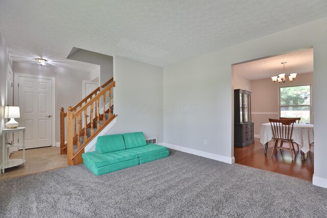 5983 Epernay Way, Galloway, OH 43119 - unfurnished room with carpet floors, stairway, a chandelier, and a textured ceiling