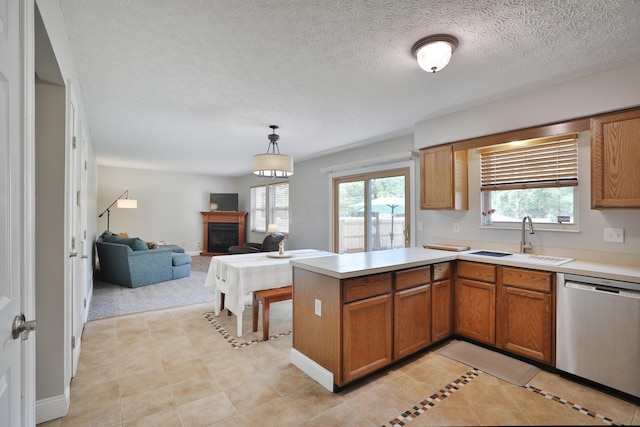 5983 Epernay Way, Galloway, OH 43119 - kitchen featuring stainless steel dishwasher, a peninsula, a fireplace, brown cabinetry, and a textured ceiling