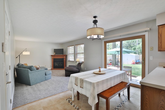 5983 Epernay Way, Galloway, OH 43119 - dining space featuring light tile patterned floors, a glass covered fireplace, and a textured ceiling