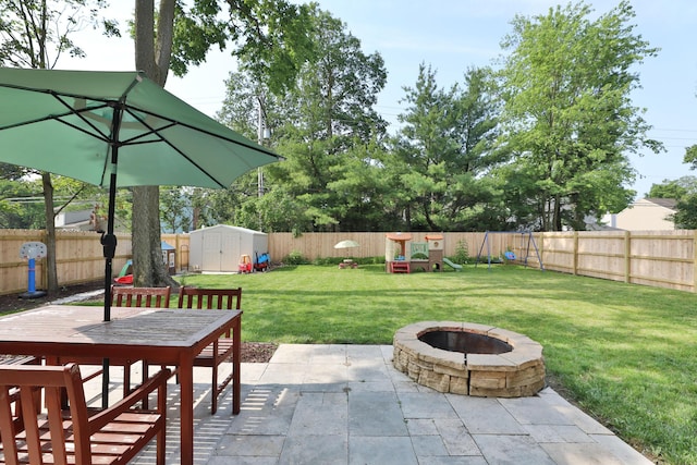 5983 Epernay Way, Galloway, OH 43119 - fenced backyard with a patio, a shed, a fire pit, a playground, and outdoor dining space