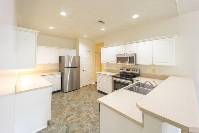 147 Shadymere Ln, Columbus, OH 43213 - kitchen with stainless steel appliances, a peninsula, stone finish flooring, recessed lighting, and light countertops