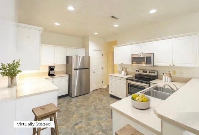147 Shadymere Ln, Columbus, OH 43213 - kitchen with stainless steel appliances, light stone finish flooring, white cabinets, light countertops, and recessed lighting