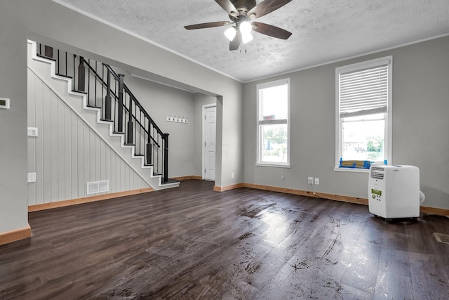 212 S Pickaway St, Circleville, OH 43113 - unfurnished living room with dark wood-style flooring, ornamental molding, a textured ceiling, stairs, and ceiling fan