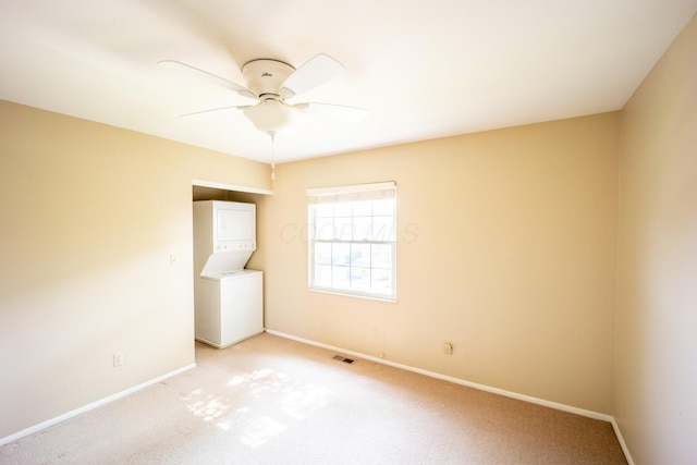 83 Tarryton Ct W, Columbus, OH 43228 - spare room featuring stacked washing machine and dryer, a ceiling fan, and light carpet