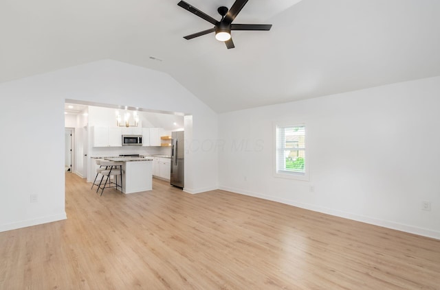 165 W Jersey St, Johnstown, OH 43031 - unfurnished living room with lofted ceiling, light wood-style floors, a ceiling fan, and a chandelier