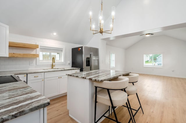 165 W Jersey St, Johnstown, OH 43031 - kitchen featuring stainless steel fridge, lofted ceiling, a kitchen island, open floor plan, and decorative backsplash