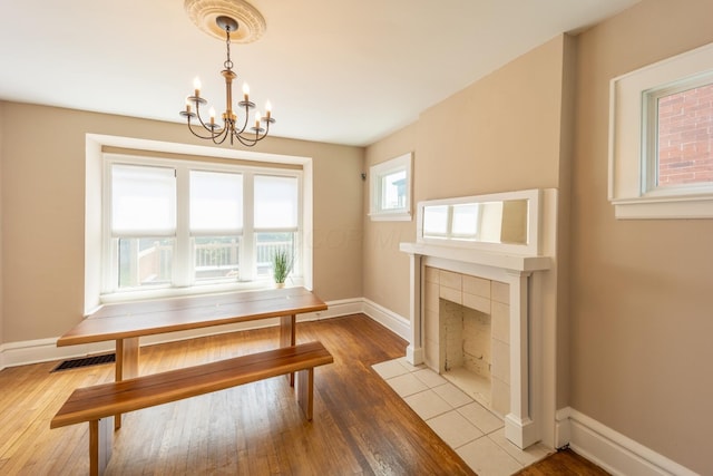 56 S Champion Ave, Columbus, OH 43205 - dining space with a chandelier, wood finished floors, and a fireplace