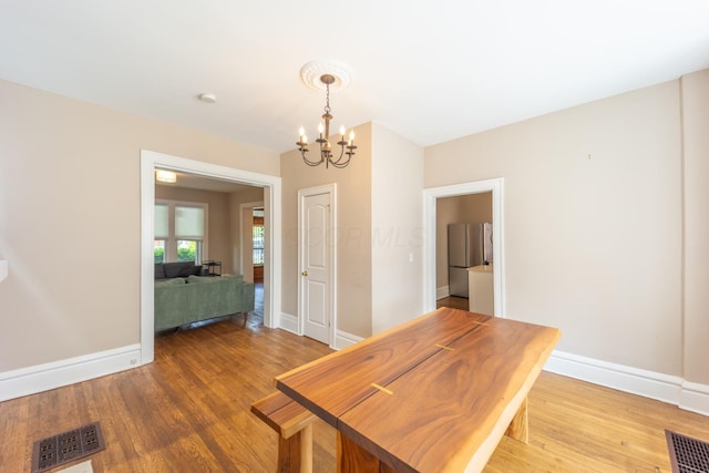 56 S Champion Ave, Columbus, OH 43205 - dining room featuring a chandelier and light wood-style flooring