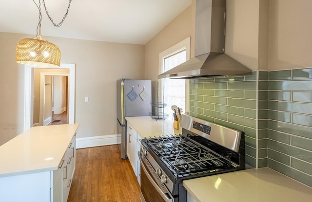 56 S Champion Ave, Columbus, OH 43205 - kitchen featuring appliances with stainless steel finishes, wall chimney exhaust hood, wood finished floors, decorative backsplash, and white cabinetry