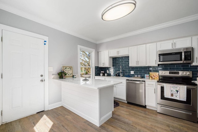 670-672 E Jenkins Ave, Columbus, OH 43207 - kitchen with stainless steel appliances, light countertops, decorative backsplash, crown molding, and a peninsula