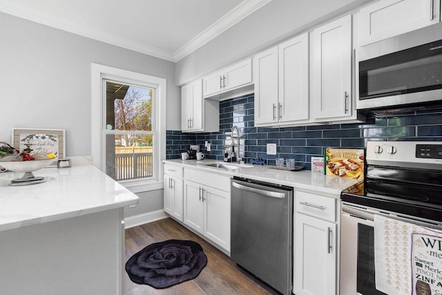670-672 E Jenkins Ave, Columbus, OH 43207 - kitchen featuring appliances with stainless steel finishes, crown molding, tasteful backsplash, white cabinetry, and dark wood-style flooring