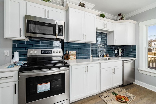670-672 E Jenkins Ave, Columbus, OH 43207 - kitchen with stainless steel appliances, ornamental molding, light countertops, white cabinetry, and tasteful backsplash