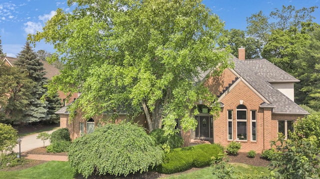 3917 Tarrington Ln, Columbus, OH 43220 - view of front of house with brick siding, a chimney, and roof with shingles