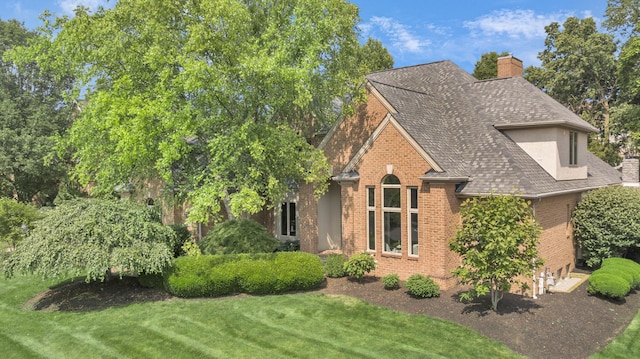 3917 Tarrington Ln, Columbus, OH 43220 - view of front of home with brick siding, a chimney, a front lawn, and a shingled roof