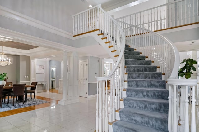 3917 Tarrington Ln, Columbus, OH 43220 - stairway with tile patterned floors, crown molding, a chandelier, and ornate columns