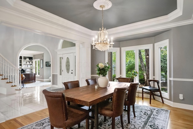 3917 Tarrington Ln, Columbus, OH 43220 - dining space with plenty of natural light, a raised ceiling, arched walkways, a chandelier, and crown molding