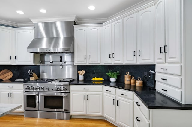 3917 Tarrington Ln, Columbus, OH 43220 - kitchen with range with two ovens, wall chimney exhaust hood, white cabinets, ornamental molding, and light wood finished floors