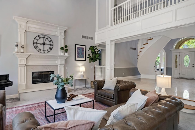 3917 Tarrington Ln, Columbus, OH 43220 - living room with stairway, a towering ceiling, a premium fireplace, and arched walkways