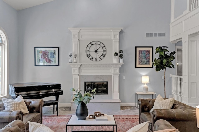 3917 Tarrington Ln, Columbus, OH 43220 - living room with a high ceiling, a premium fireplace, and light colored carpet