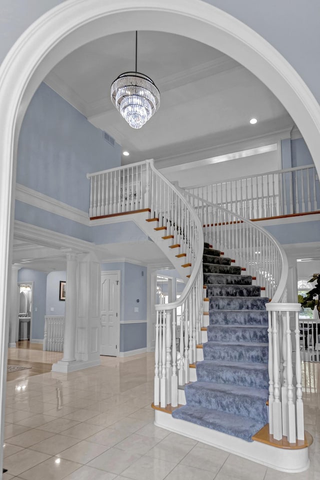3917 Tarrington Ln, Columbus, OH 43220 - stairs featuring a high ceiling, arched walkways, a chandelier, tile patterned flooring, and crown molding