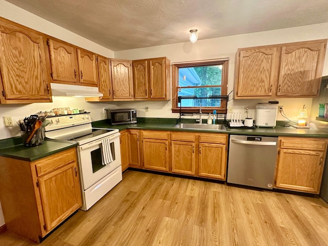 158 Kennedy Blvd, Leesburg, OH 45135 - kitchen featuring stainless steel appliances, under cabinet range hood, dark countertops, and light wood-style flooring