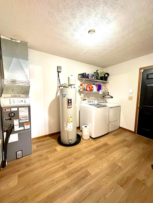 158 Kennedy Blvd, Leesburg, OH 45135 - laundry area with electric water heater, washer and clothes dryer, a textured ceiling, light wood-style floors, and heating unit