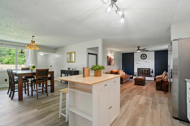248 Grandview Ave, Delaware, OH 43015 - kitchen featuring freestanding refrigerator, a textured ceiling, white cabinetry, light wood-style flooring, and open floor plan